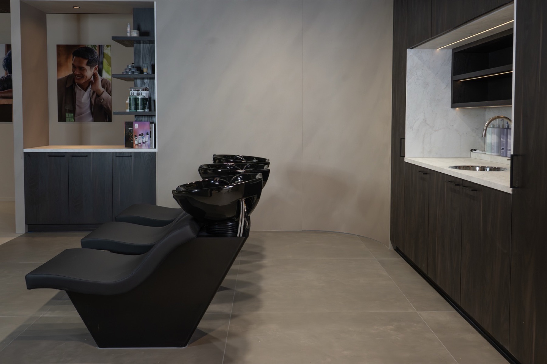 Paul Mitchell wasruimte met spoelunits en verzorgingsproducten